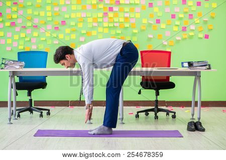 Man in the office with many conflicting priorities doing exercis