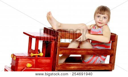 Beautiful Little Caucasian Girl With A Short Bangs And Hair Tucked Into A Tail. In Striped In A T-sh