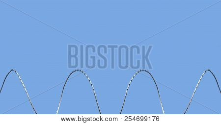 Gate Barb Razor Wire Against Blue Sky