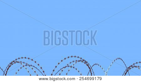Gate Barb Razor Wire Against Blue Sky