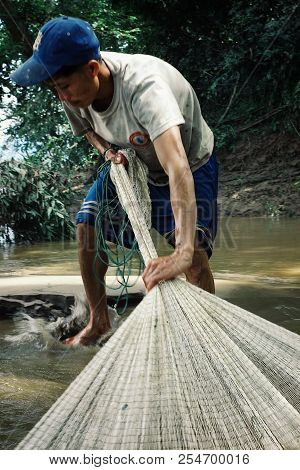 Nong Khiaw / Laos - Jul 06 2011: Lao Fisherman Istalom At Work At One Of The Small River Stream Lead