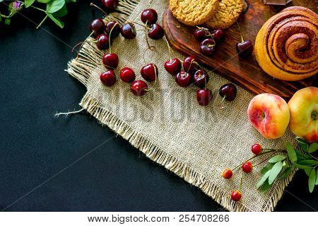 Homemade Cinnamon Buns In Glaze On A Dark Plate With Berries