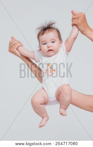 Dad Raised His Daughter In His Arms On A White Background. Girl In Fly