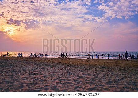 The Sand Beach On Bengal Bay With The Silhouettes Of People In Purple Sunset Light, Chaung Tha, Myan