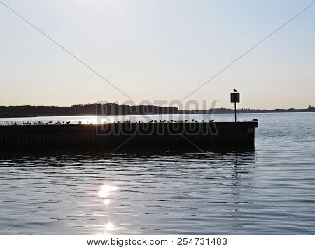 Wharf Catwalk During Sunset Over Beautiful Lake With Cloudy Sky In The Background
