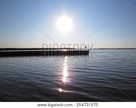 Wharf Catwalk During Sunset Over Beautiful Lake With Cloudy Sky In The Background