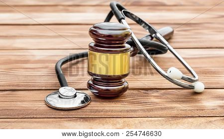 Gavel With Stethoscope On Wooden Table. Medical Law.