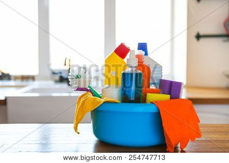 Basket With Cleaning Items On Blurry Background White Citchen. Cleaning Concept.