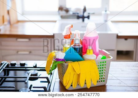 Basket With Cleaning Items On Blurry Background White Citchen. Cleaning Concept.