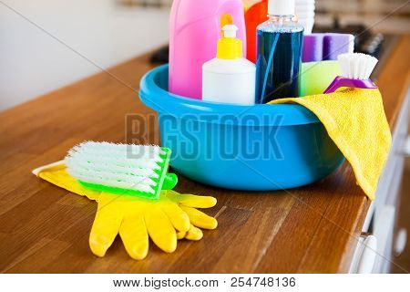 Basket With Cleaning Items On Blurry Background White Citchen. Cleaning Concept.
