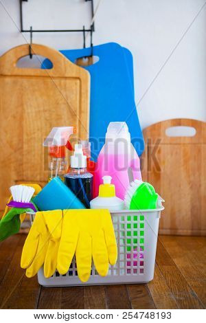 Basket With Cleaning Items On Blurry Background White Citchen. Cleaning Concept.