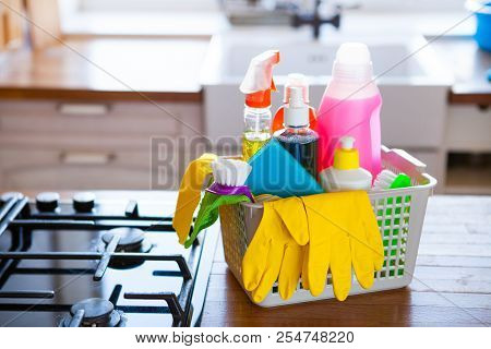 Basket With Cleaning Items On Blurry Background White Citchen. Cleaning Concept.