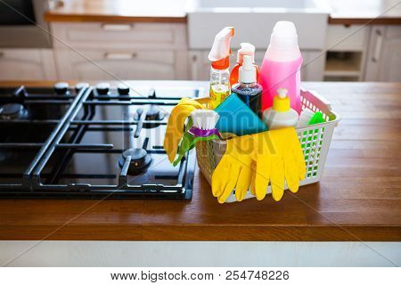 Basket With Cleaning Items On Blurry Background White Citchen. Cleaning Concept.
