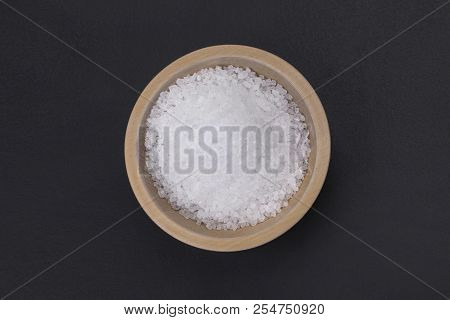 Natural Sea Iodized Salt In A Small Wooden Bowl Isolated On A Black Background, Top View