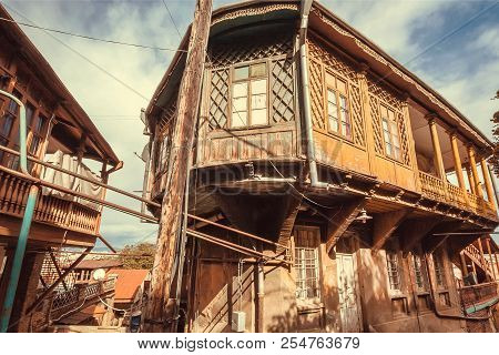 Wooden Grunge House With Old Facade, Windows, Decor In Traditional Style Built In Historical Area Of