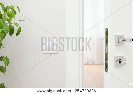 Close-up Elements Of The Interior Of The Apartment. Ajar White Door. Chrome Door Handle And Lock Wit