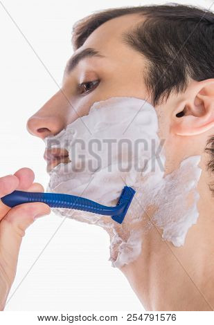 Young Topless Man With Shaving Foam Applied Shaving Using Razor