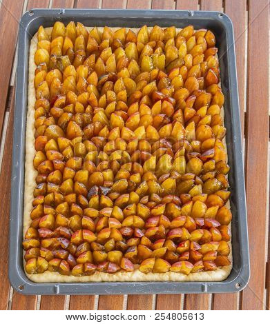 German Traditional Open Pie Made Of Plums On The Baking Sheet.