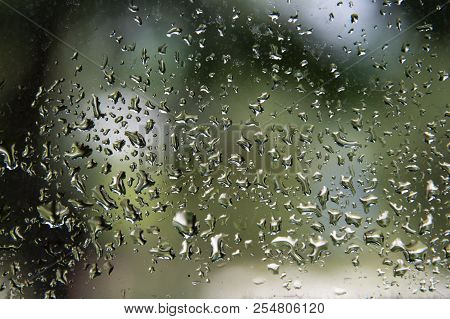 Droplets Of Water On A Window In Front Of A Blurred Background