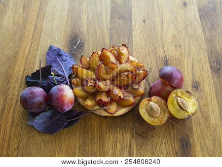 Tartlet Of Fresh Plum, Fresh Plum Fruit On A Wooden Board.