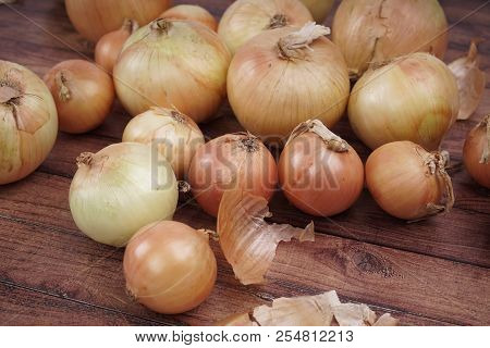 Fresh Onion Bulbs On Wooden Background. Vegetables For A Healthy Diet. Bulb Onion Is Rich In Vitamin
