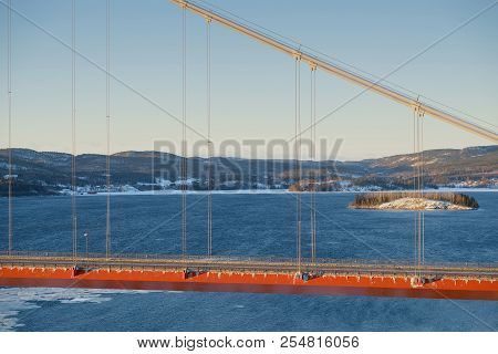 View At Hoga Kusten Bridge In Winter In Sweden. Hoga Kusten Suspension Bridge In Sweden.