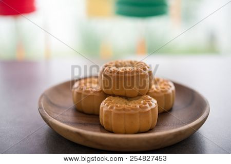 Mooncakes is traditionally baked pastry to eaten during Mid-Autumn Festival. Lanterns at background. The Chinese character on the moon cake represent 