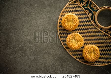 Traditional pastry mooncakes is offered to friends or family during Mid-Autumn Festival. Flatlay table top view dark light with copy space. The Chinese character  represent 