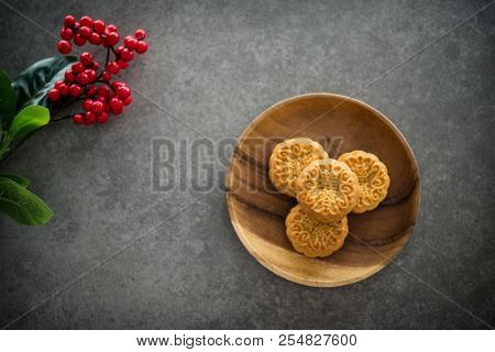 Traditional baked mooncakes is offered to friends or family during Mid-Autumn Festival. Flatlay on table top down view dark background with copy space. The Chinese character  represent 
