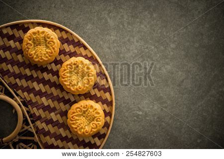 Traditional pastry moon cakes is offered to friends or family during Mid-Autumn Festival. Flatlay on table, top down view dark light with copy space. The Chinese character represent 
