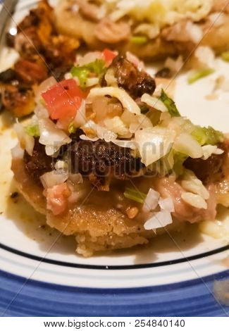 Sopes, A Typical Mexican Food Dish. Onion, Jalapeno, Chili, Beans, Green Sauce, Cheese, Tomato, Past