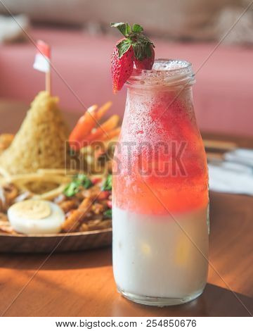 Strawberry Smoothie Milk Shake In The Bottle With Blur Background Of Nasi Tumpeng For Celebration An