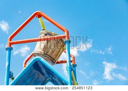 A Large Bucket Of Water Splashing Down At A Water Park