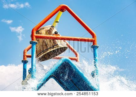 A Large Bucket Of Water Splashing Down At A Water Park