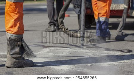 Workers Repair The Road, Pour Small Cracks With Bitumen To Prevent Further Destruction Of The Road S