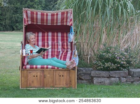 Fashionably Dressed In Green, A Bikini, Sunscreen And A Funny Book, So The Young Woman Spends The Da