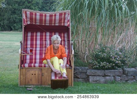 The Sunscreen Was Not Forgotten By The Attractive Woman In The Roofed Wicker Beach Chair