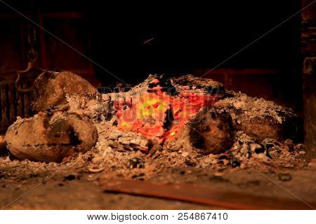 Burning Coals In The Fireplace On A Blurred Background, The Texture Of The Flame