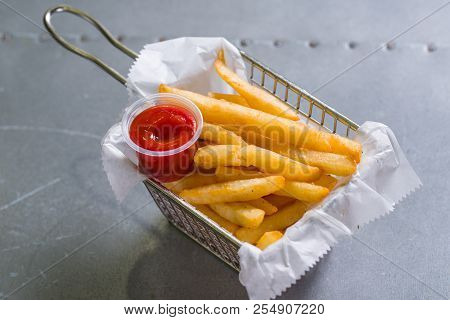 French Fries In A Steel Basket On A Table