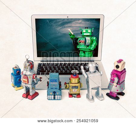 Machine learning concept with retro robots at a laptop computer isolated  E= mc