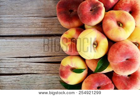 Fresh Organic Chinese Flat Peaches With Leaves On Old Wooden Background.saturn Donut, Doughnut Peach
