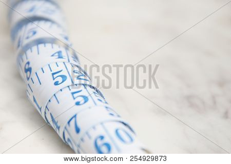 Measurring Tape Metter With Blue Figures Over Marbble Background. Control Weight, Loose Weight. Isoa