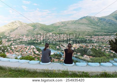 rear view two young girls sitting in front at great landscape, Bosnia and Herzegovina 