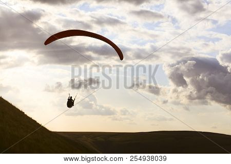 A Paraglider Is Silhouetted Against The Sky Over Edale Valley In The Peak District, Derbyshire. The 