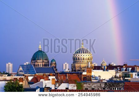 Berlin Cathedral And New Synagogue Domes In Berlin, Germany Adorned With A Rainbow After A Summer St