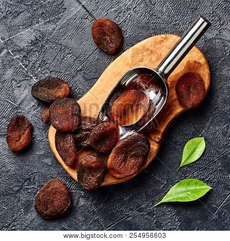 Brown Sun Dried Apricots On Black Table. Top View.