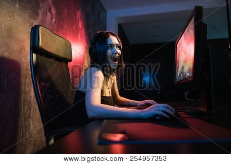 A Cute Female Gamer Girl Sits In A Cozy Room Behind A Computer And Plays Games. Woman Live Streaming
