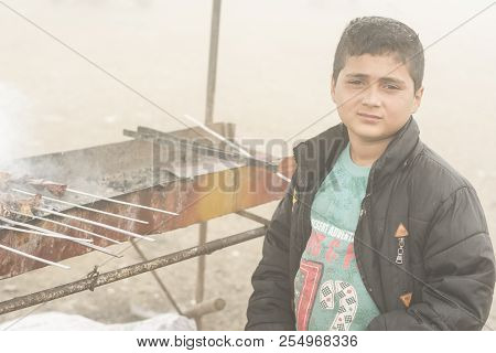 Gilan Province- Iran-july 23, 2018 Portrait Of A Teenage Boy Making Kebab In Fogy Day Beside Travel 