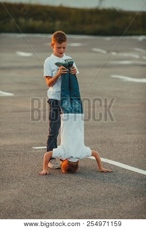 The Boy Standing Upside Down In The Summer Outdoors
