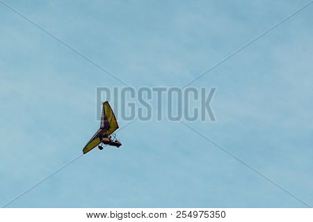 The Hang-glider On A Background Blue Sky With Light Clouds. Flying A Gyroplane.